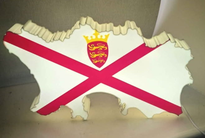 A USB LED lightbox in the shape of the Jersey (Channel Islands) flag, illuminated and displaying the design on a wall.