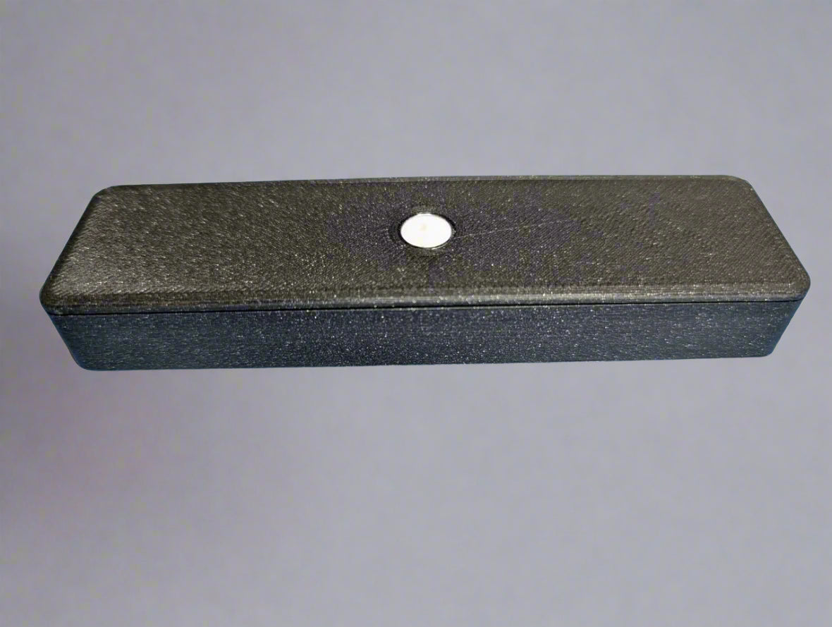 Black rectangular object with a central hole on a blue background