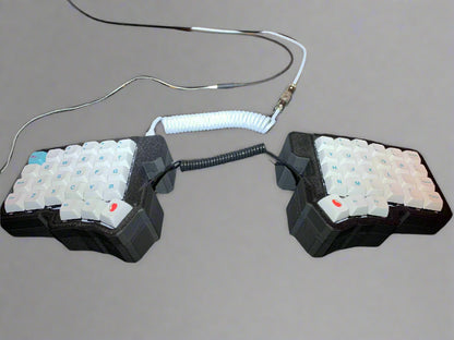 Pair of mechanical keyboard keycaps on a desk with visible cables.